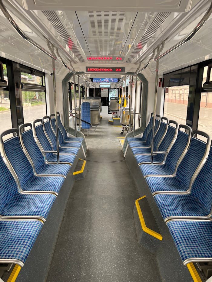 Inside view of an empty modern tram with blue seats and clean design, showcasing public transport infrastructure.