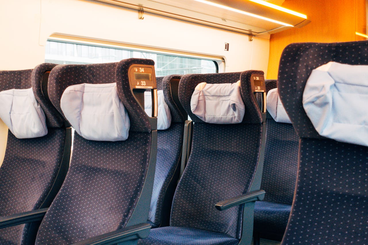 Interior view of modern train seats featuring polka-dot upholstery and headrests.