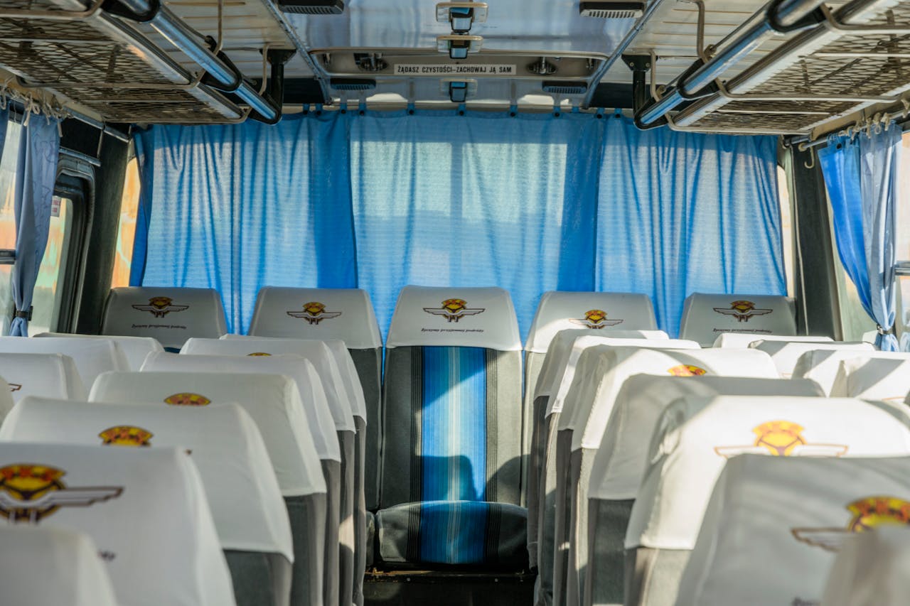 Empty bus interior with blue curtains and seat covers in Wrocław, Poland.